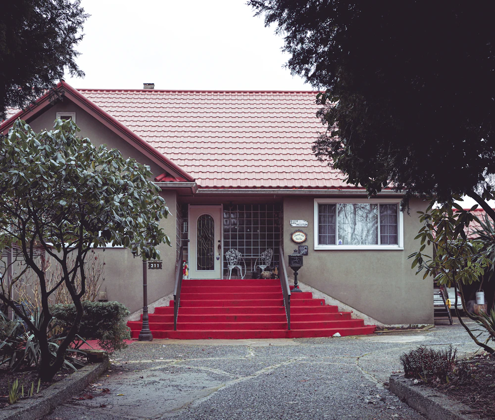 A home with a tiled roof and red front steps, framed by trees